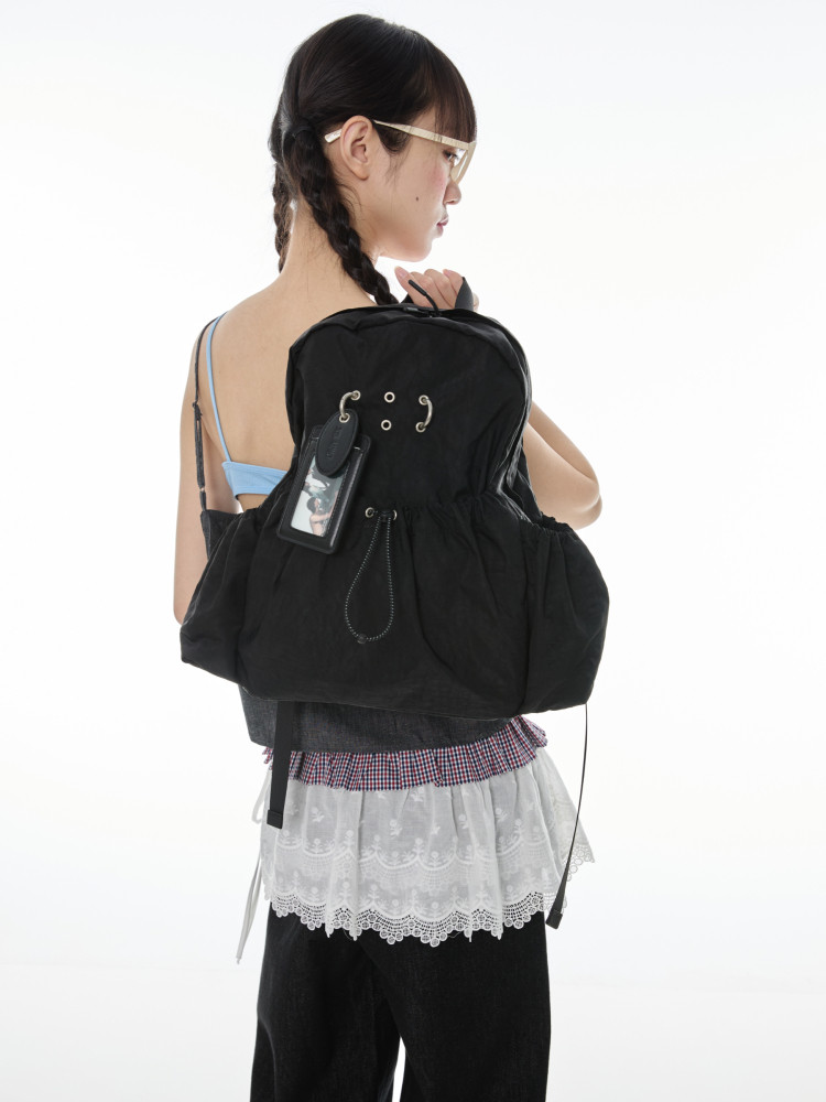 Black backpack worn by a model against a white background