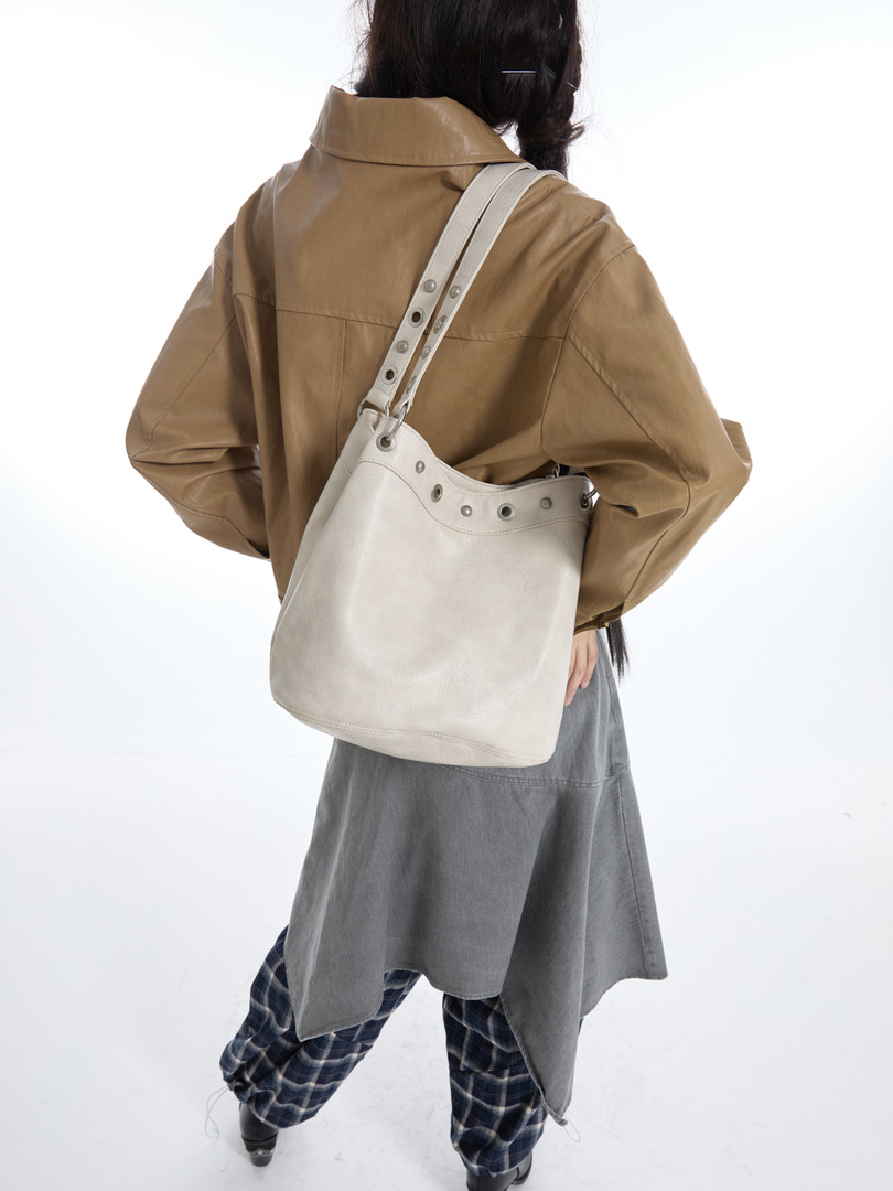 White leather shoulder bag worn crossbody on a model