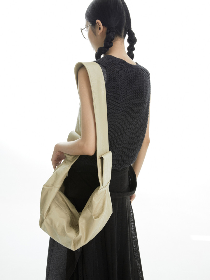 Beige slouchy shoulder bag worn by a model