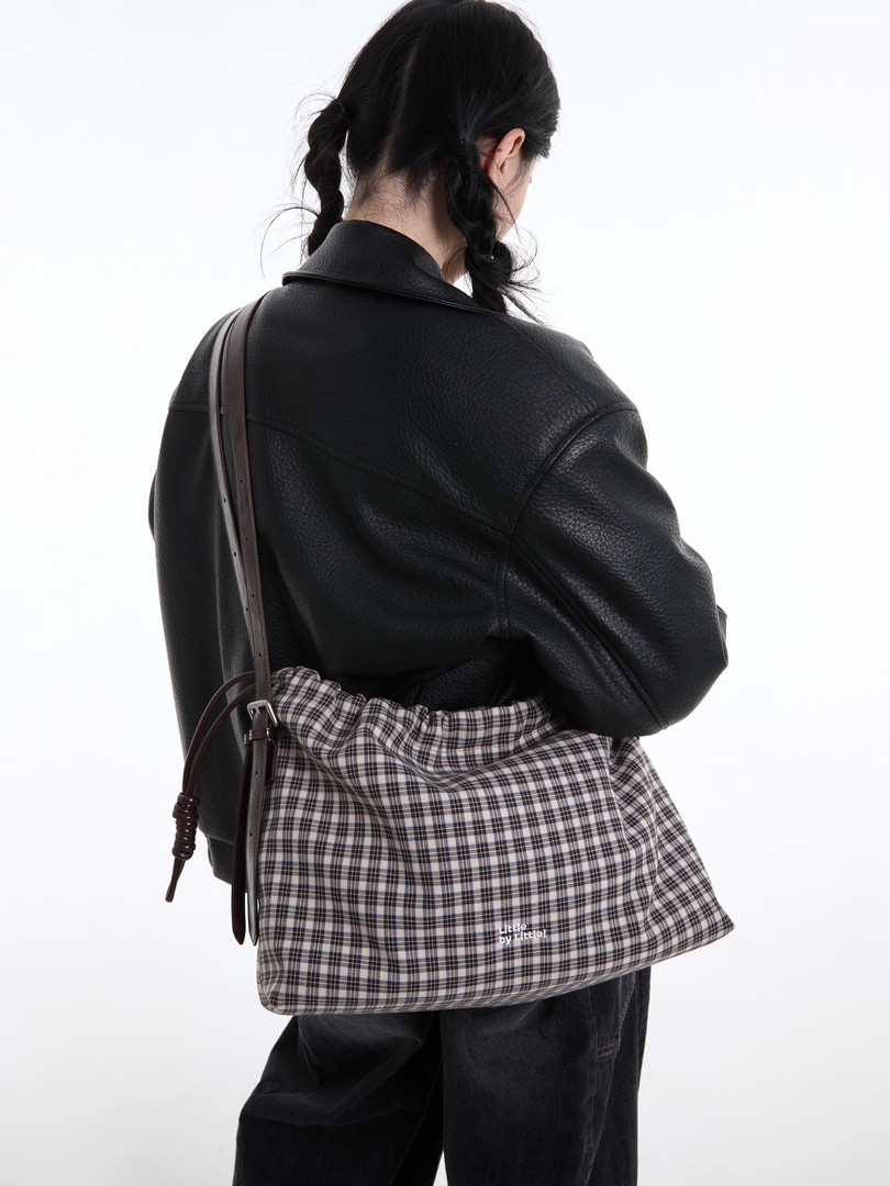 Plaid shoulder bag worn by a model with a black jacket
