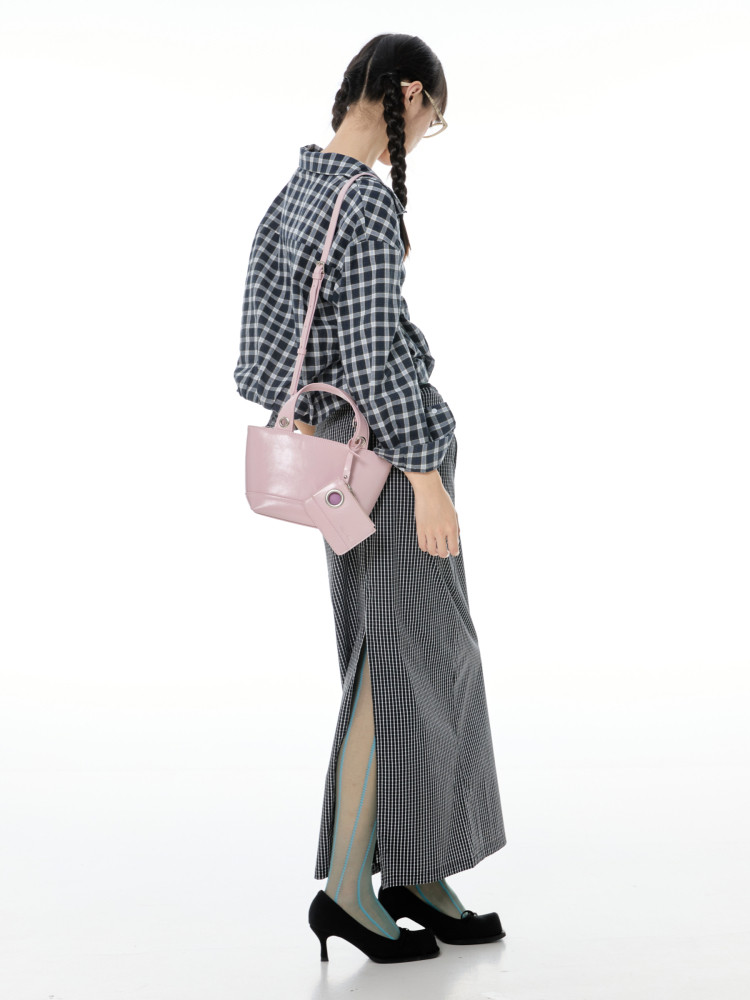 Model wearing a pink crossbody handbag with a plaid outfit