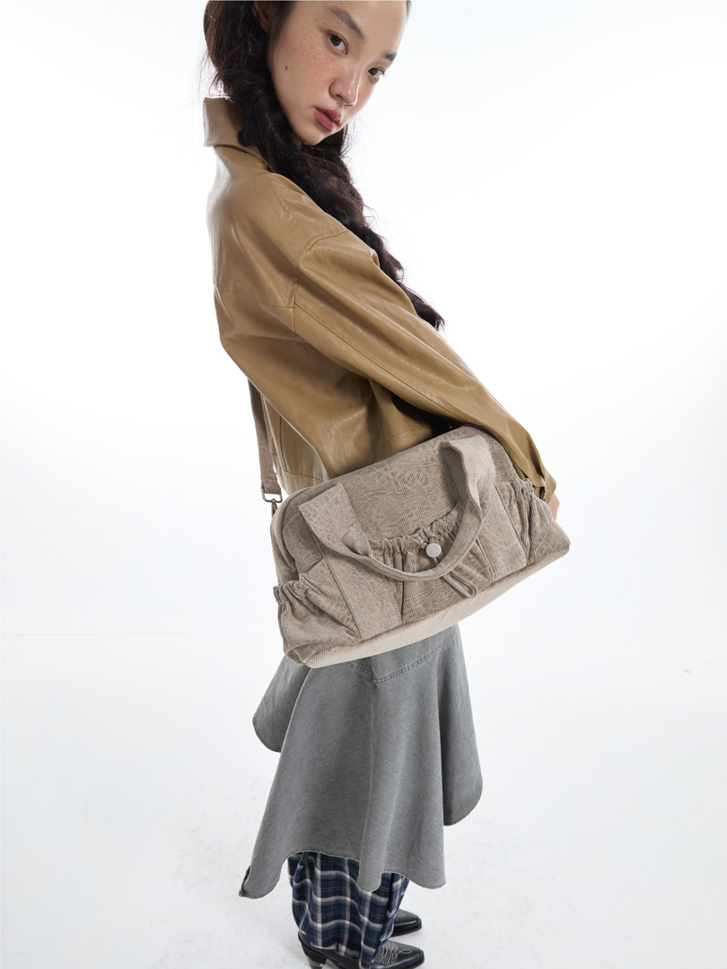 Beige corduroy shoulder bag worn by a model