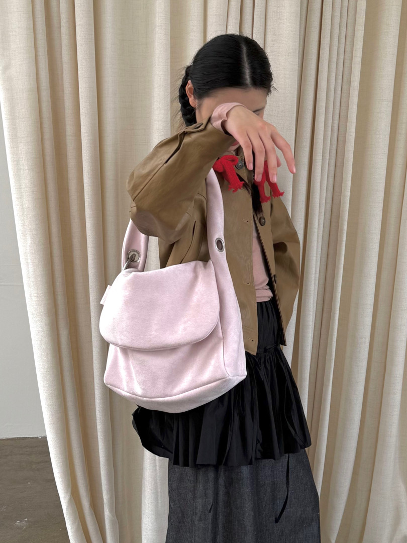 Light pink shoulder bag worn by a model