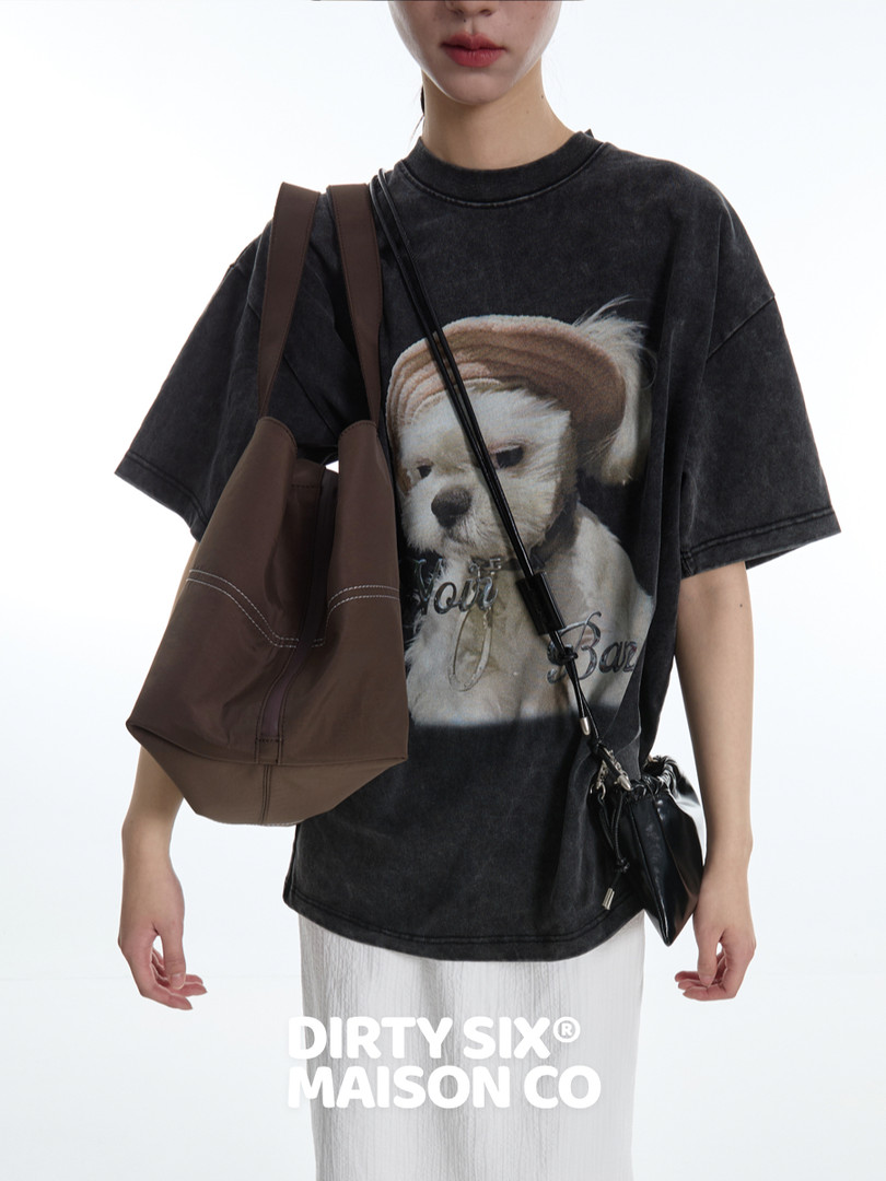 Model wearing a black graphic oversized T-shirt with a dog print and crossbody bags
