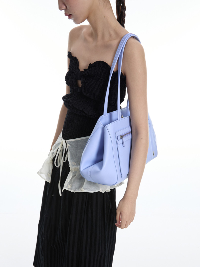 Lavender tote handbag worn by a model with a black outfit