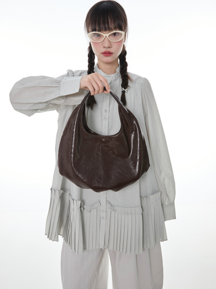 Dark brown leather hobo handbag worn and held by a model