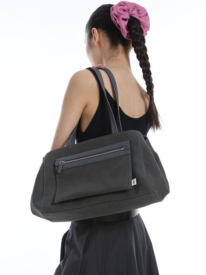 Black shoulder tote bag worn by a model