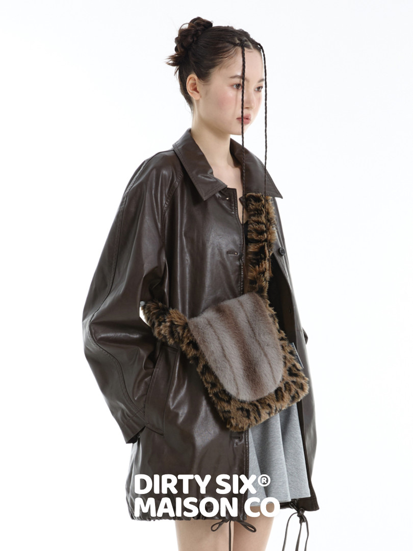 Model wearing a dark leather jacket with a fur-trim crossbody bag