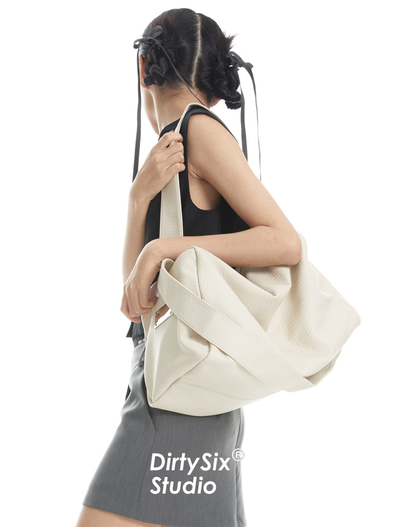 Cream oversized shoulder bag worn by a model against a white background