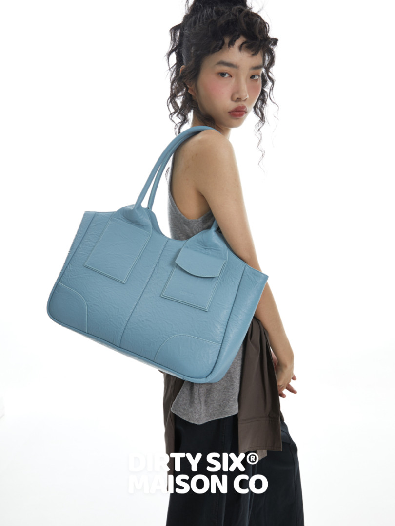 Light blue oversized tote bag worn by a model on a white background