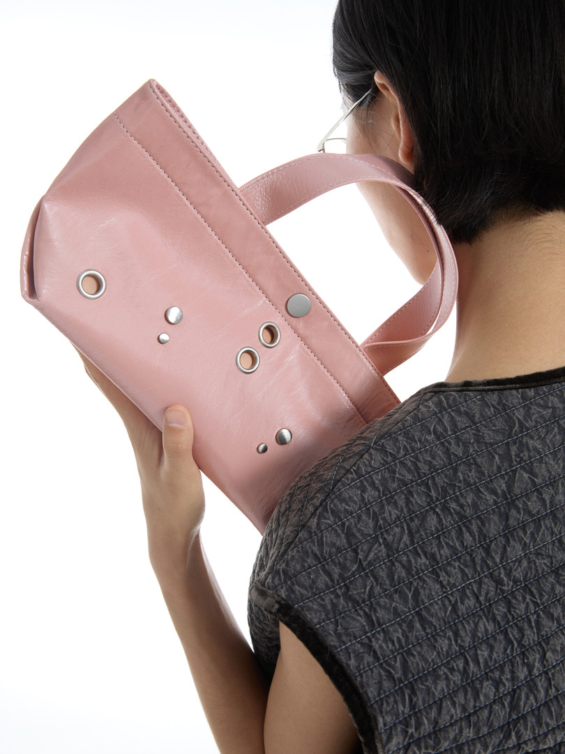 Pink leather shoulder bag worn by a model