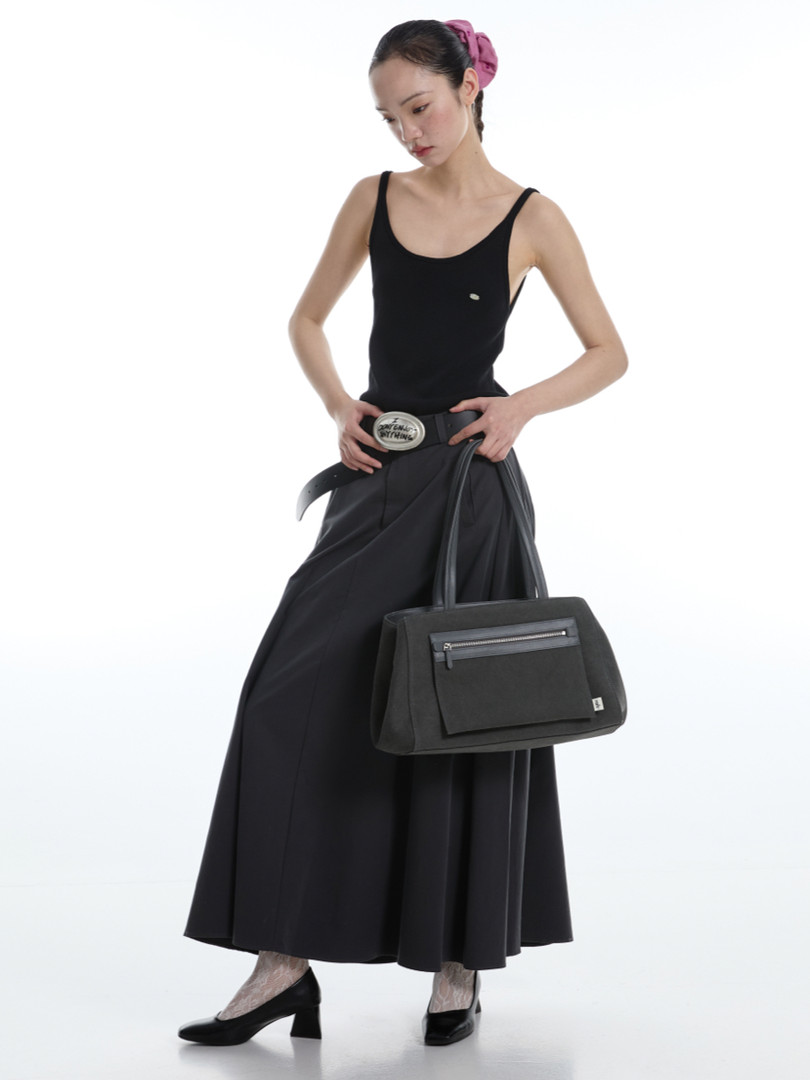 Model wearing a black tank top and long black skirt with a black handbag