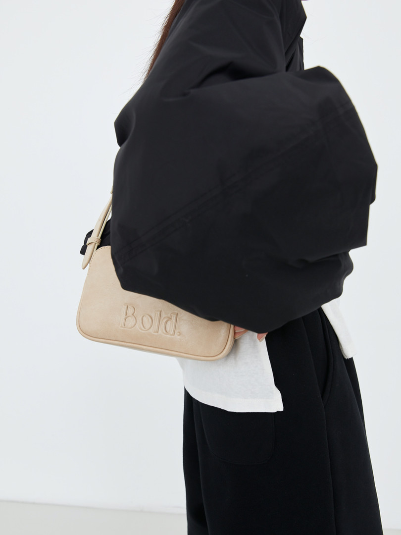 Beige crossbody bag worn with black outfit