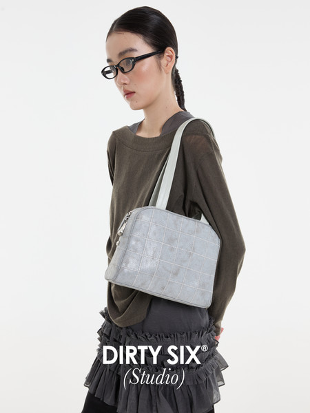Light gray quilted shoulder bag worn by a model