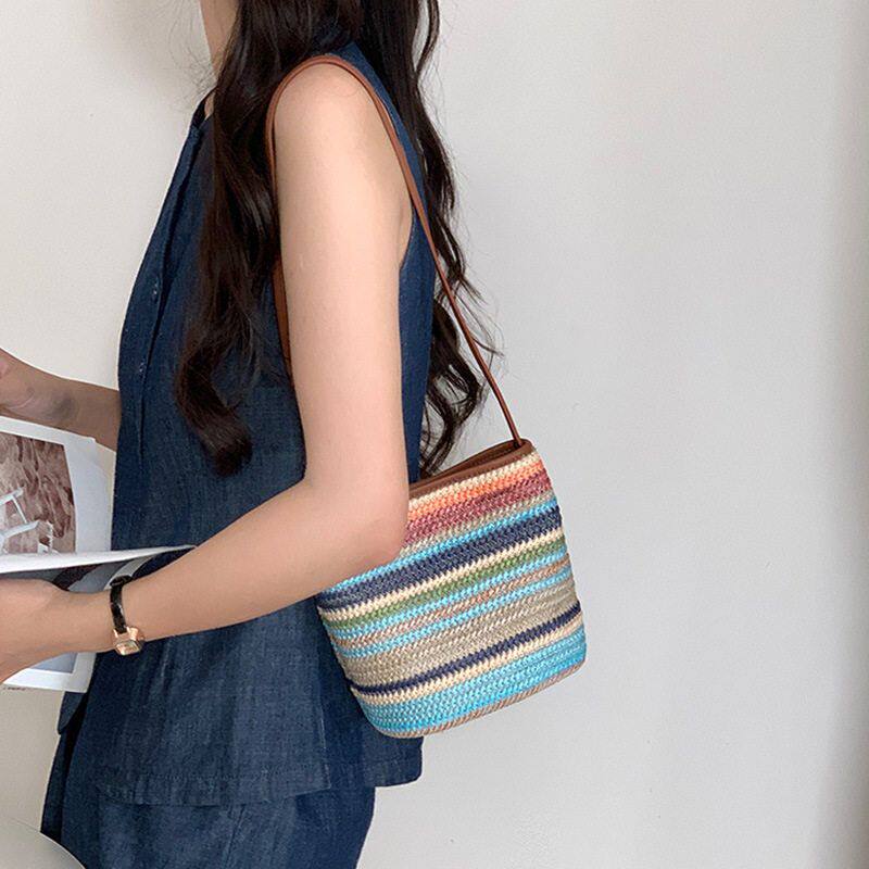 彩虹色斜挎编织包女2025新款夏日度假风草编水桶包百搭小众单肩包
