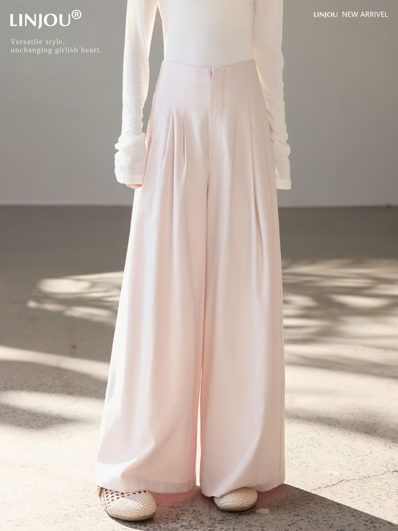 Model wearing light pink wide-leg pants with a fitted white top