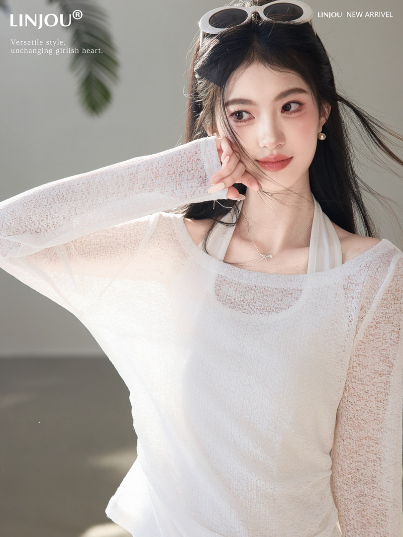Woman wearing a sheer white long-sleeve top with a light, airy look