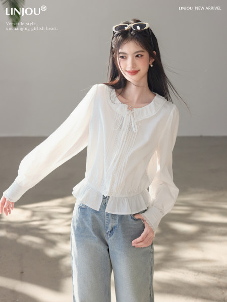 White long-sleeve blouse worn by a model with light blue jeans
