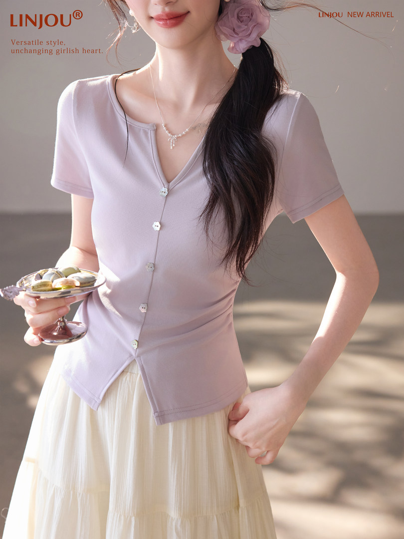 Woman wearing a light lavender short-sleeve button-front knit top with a skirt