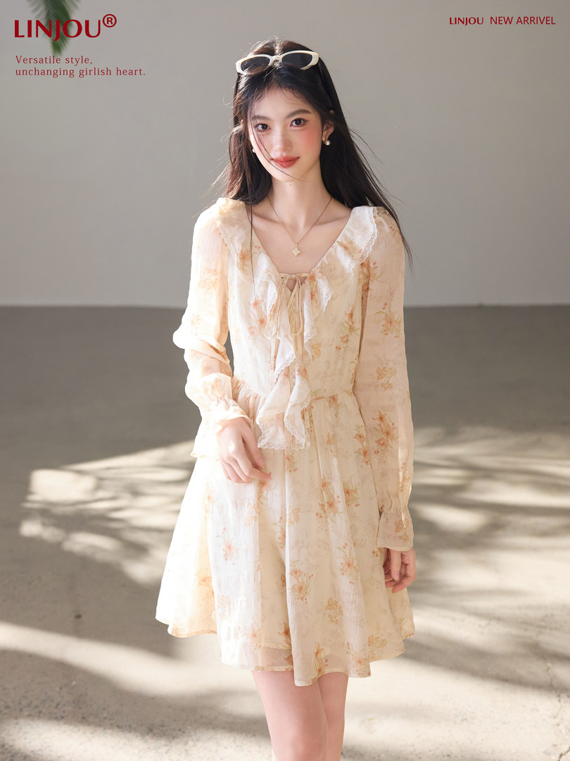 Woman wearing a light floral long-sleeve dress with ruffled trim