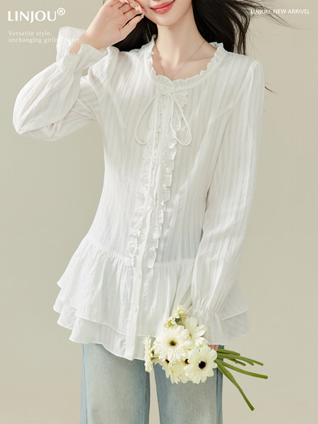 White ruffled long-sleeve blouse worn by a model