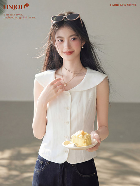 White sleeveless button-front top worn by a model with jeans