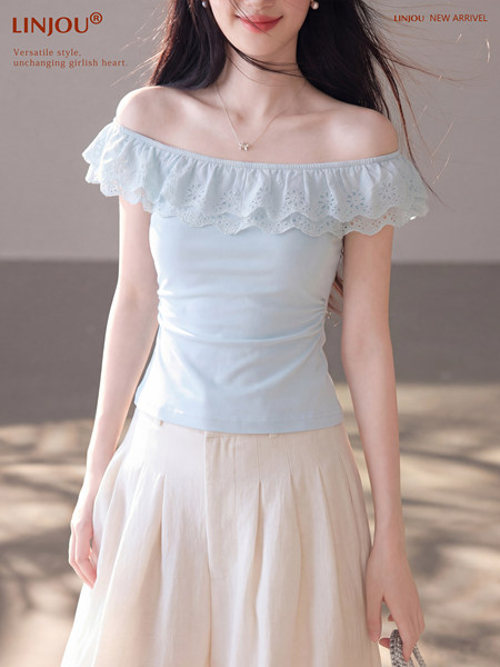 Woman wearing a light blue off-shoulder ruffled top with a delicate lace trim