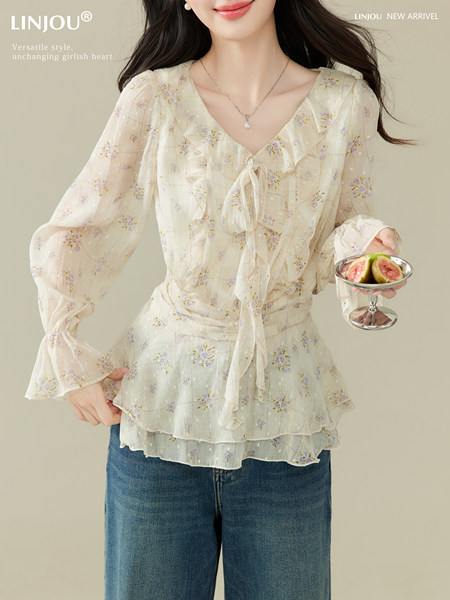 Model wearing a light floral sheer long-sleeve blouse with a tie front