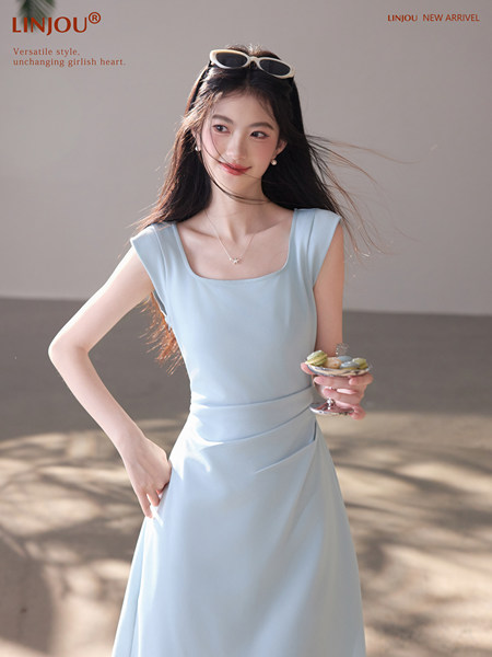 Model wearing a light blue sleeveless dress with a soft, elegant look