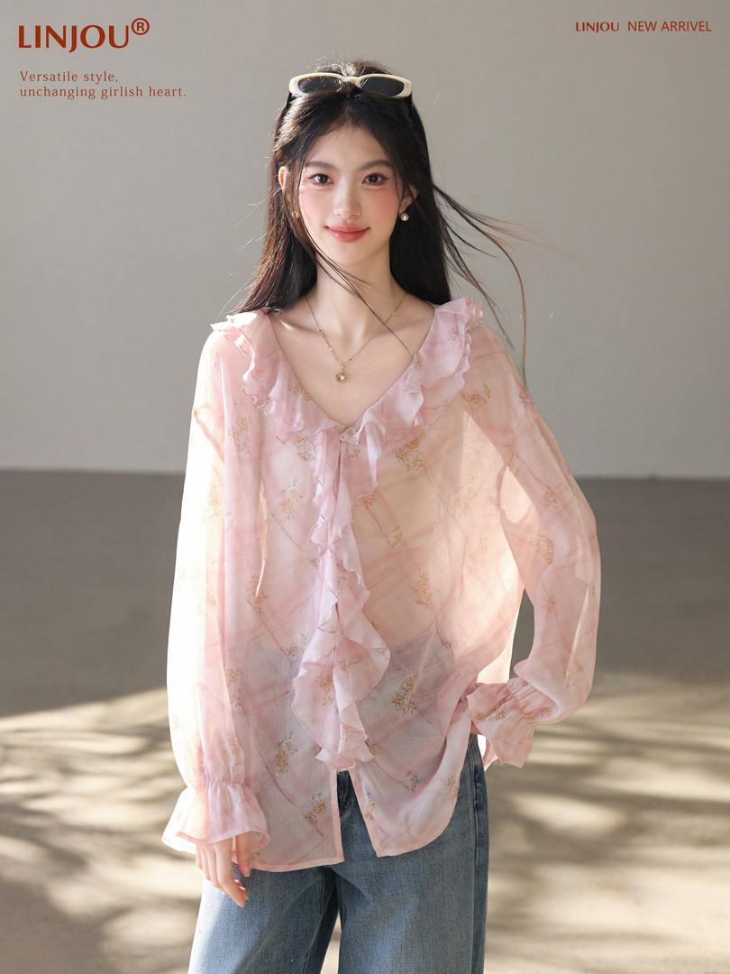 Pink ruffled floral blouse worn by a model
