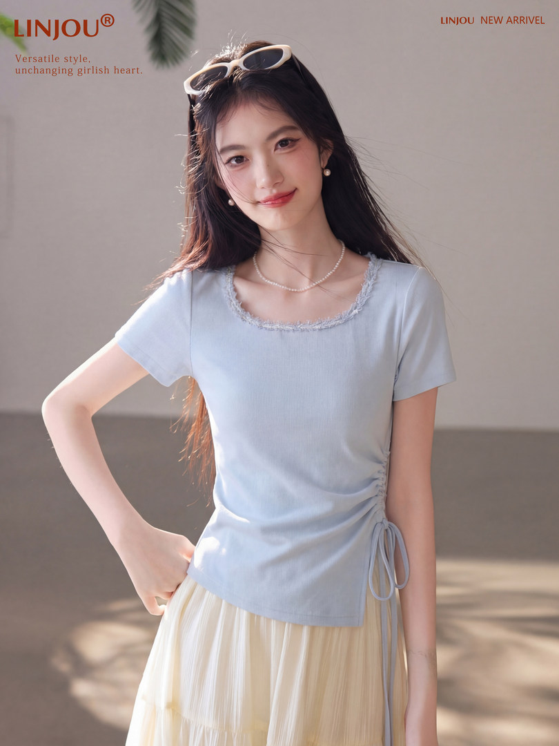 Woman wearing a light blue short-sleeve top with a cream pleated skirt