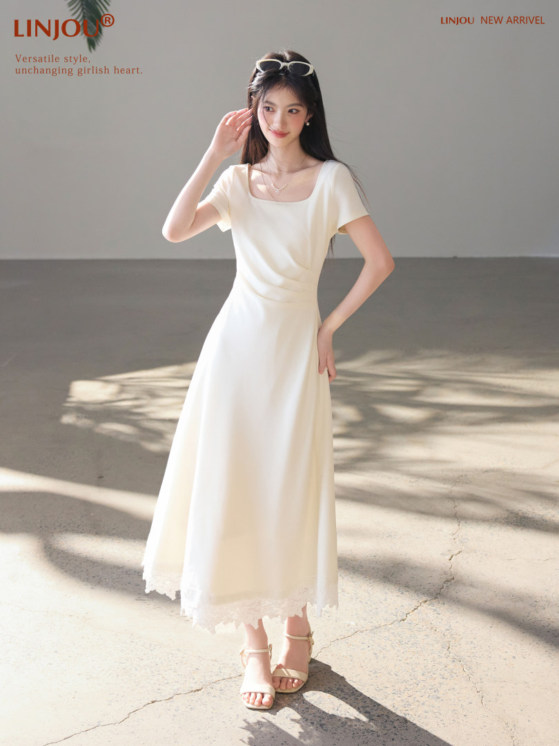 Woman wearing a cream sleeveless midi dress with sandals