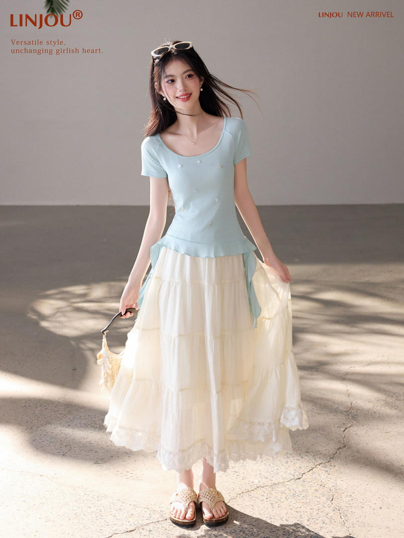Woman wearing a light blue top with a cream tiered skirt in a fashion product photo