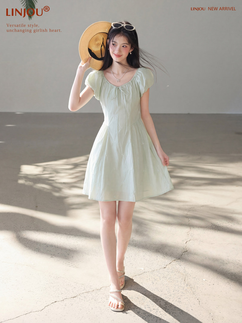Model wearing a light mint short-sleeve dress with a straw hat