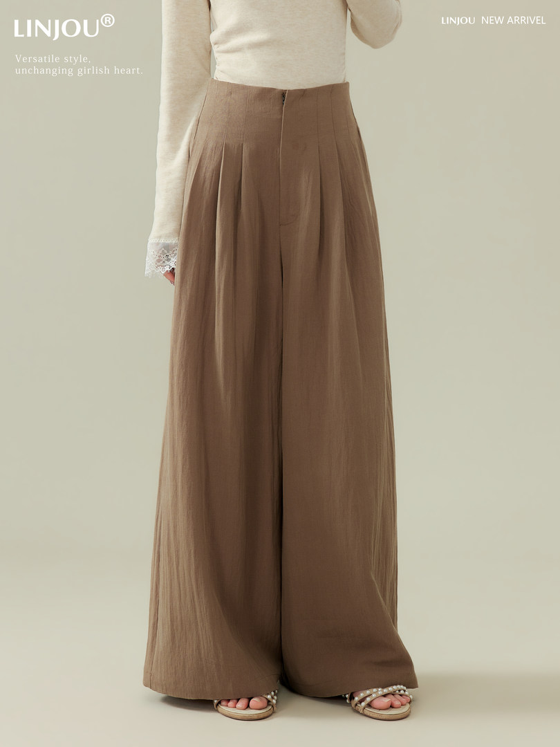 Model wearing brown wide-leg pants with a cream long-sleeve top