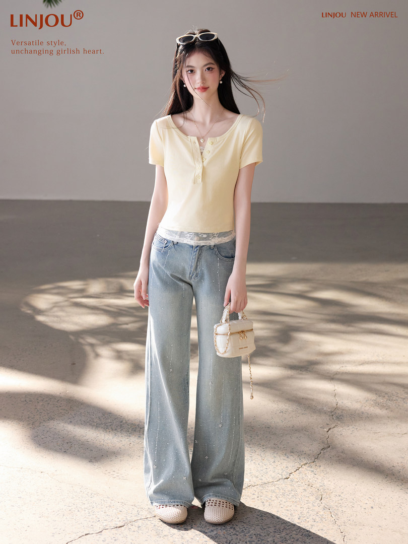Model wearing a pale yellow short-sleeve henley top with wide-leg jeans and a small handbag