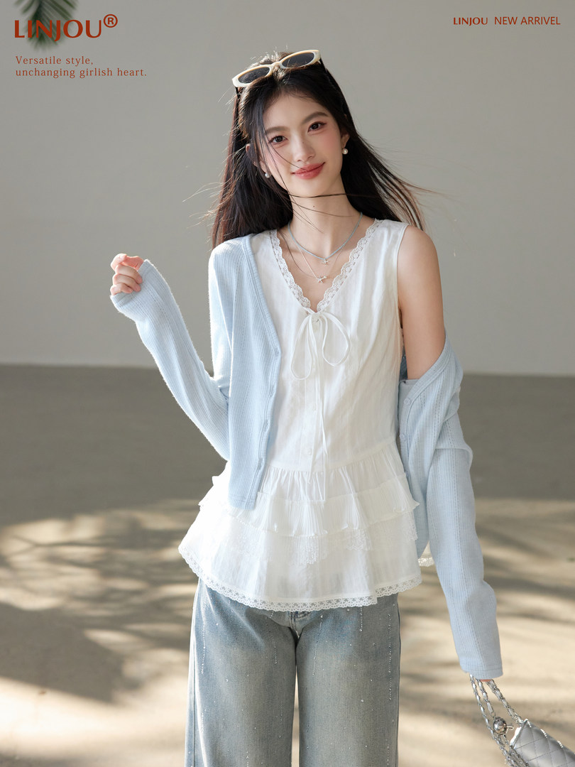 Model wearing a white lace-trim top with a light blue cardigan and wide-leg jeans