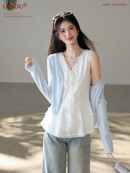 Model wearing a white lace-trim top with a light blue cardigan and wide-leg jeans