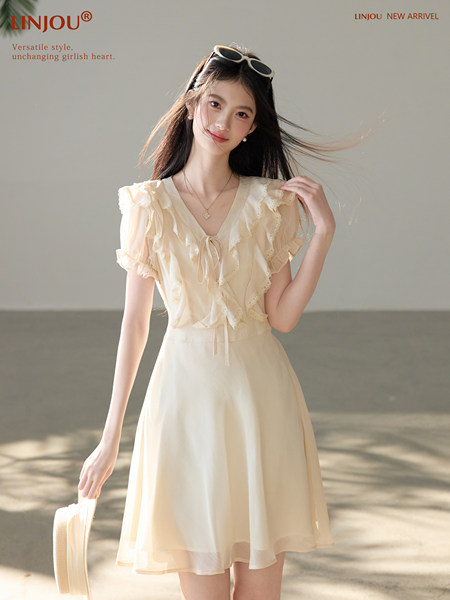 Model wearing a cream ruffled short-sleeve dress