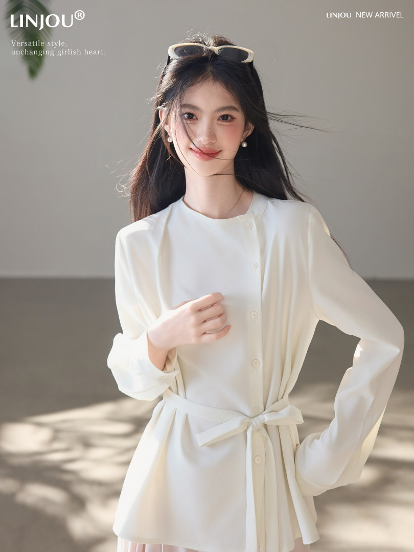 Woman wearing a white belted long-sleeve dress