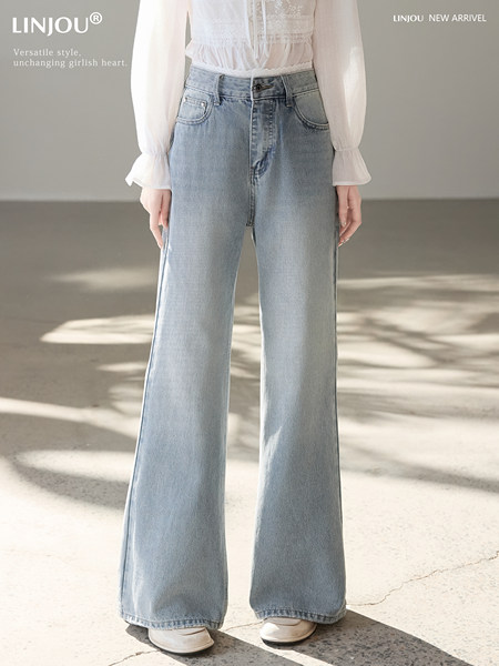 Model wearing light wash wide-leg jeans with a white blouse