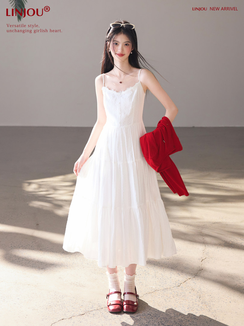 Woman modeling a white sleeveless midi dress with lace trim