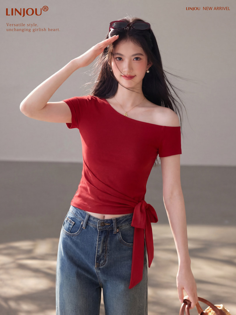 Model wearing a red off-shoulder short-sleeve top with blue jeans