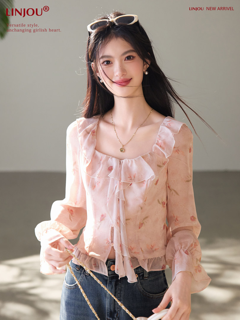 Model wearing a light pink floral ruffled sheer blouse