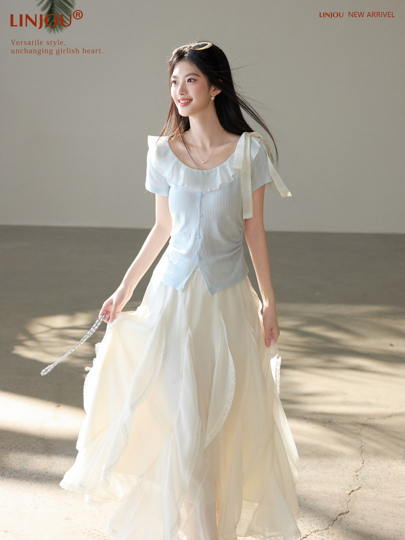 Model wearing a light blue and white feminine dress set with a flowing skirt