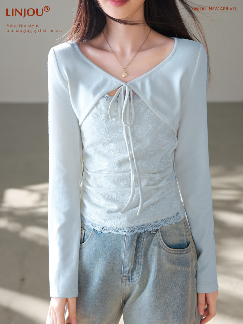 Model wearing a light blue layered lace-trim long sleeve top with jeans