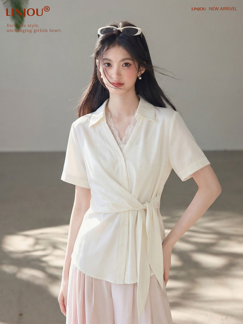 Woman wearing a white short-sleeve wrap blouse with a light pink skirt