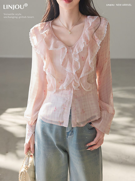 Model wearing a pink ruffled sheer blouse