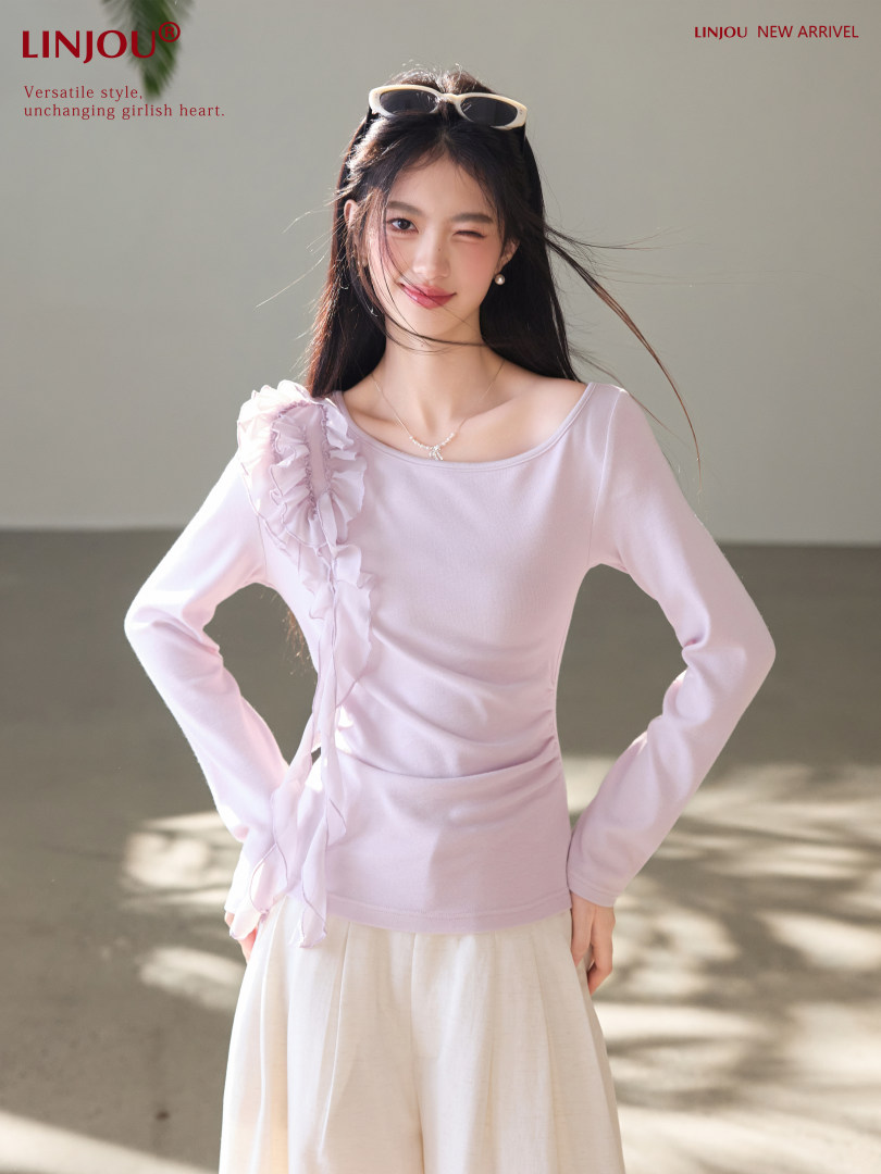 Woman wearing a light pink ruffled long-sleeve top and cream skirt