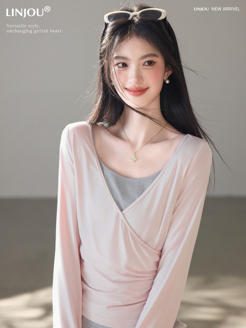 Model wearing a light pink wrap-style long-sleeve top with a layered camisole